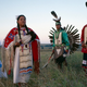 Lakota men and women in traditional costume outside Rosebud, South Dakota